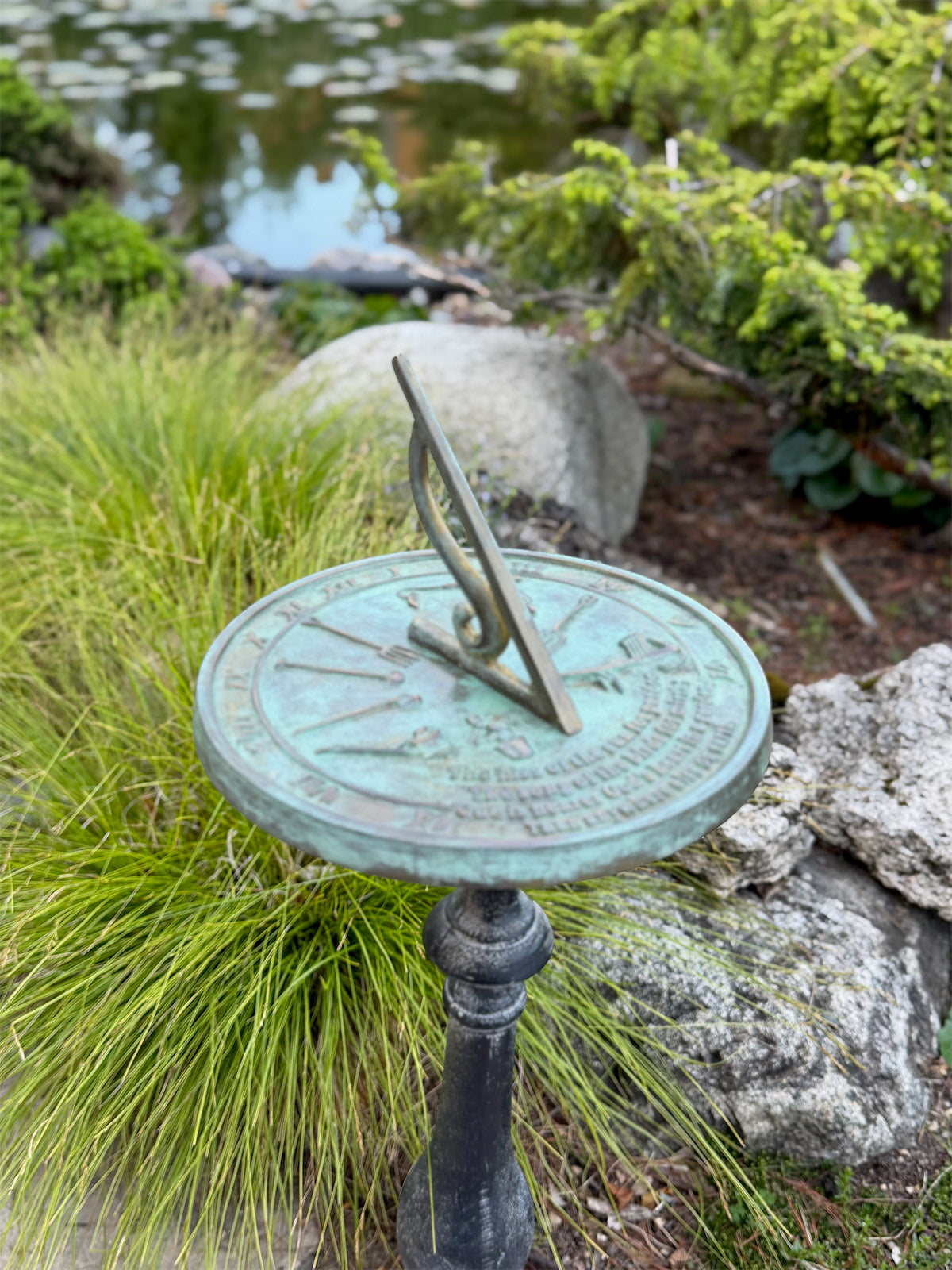 Solid Brass Kiss Of The Sun Sundial on pedestal in garden
